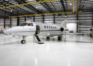 A small white airplane in an airport hangar.