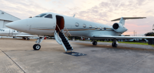 A white jet airplane sitting on top of an airport runway.